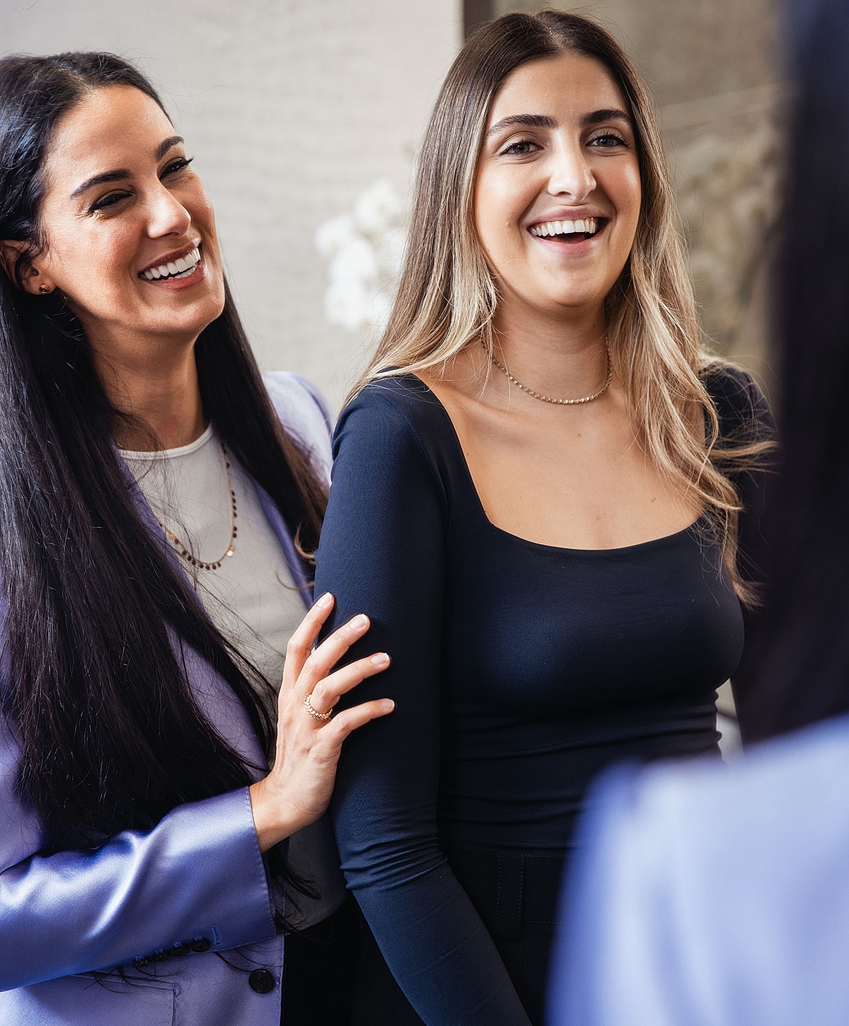 Two women smiling and enjoying a conversation.