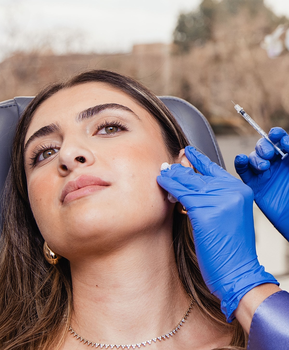 Woman receiving cosmetic treatment on her cheek.