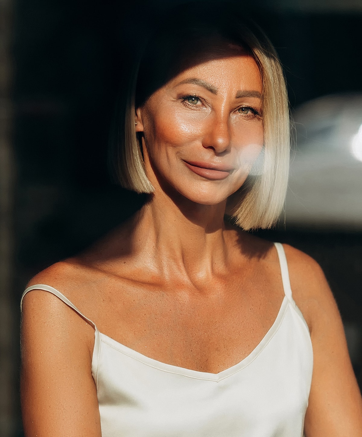 Smiling woman with short blonde hair, natural light.