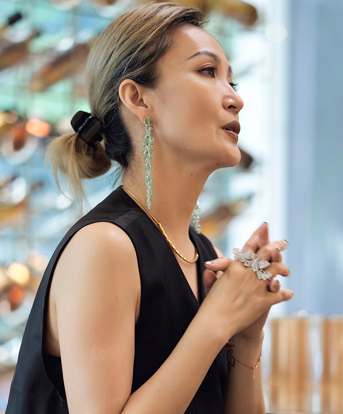 Woman with elegant earrings and jewelry speaking.