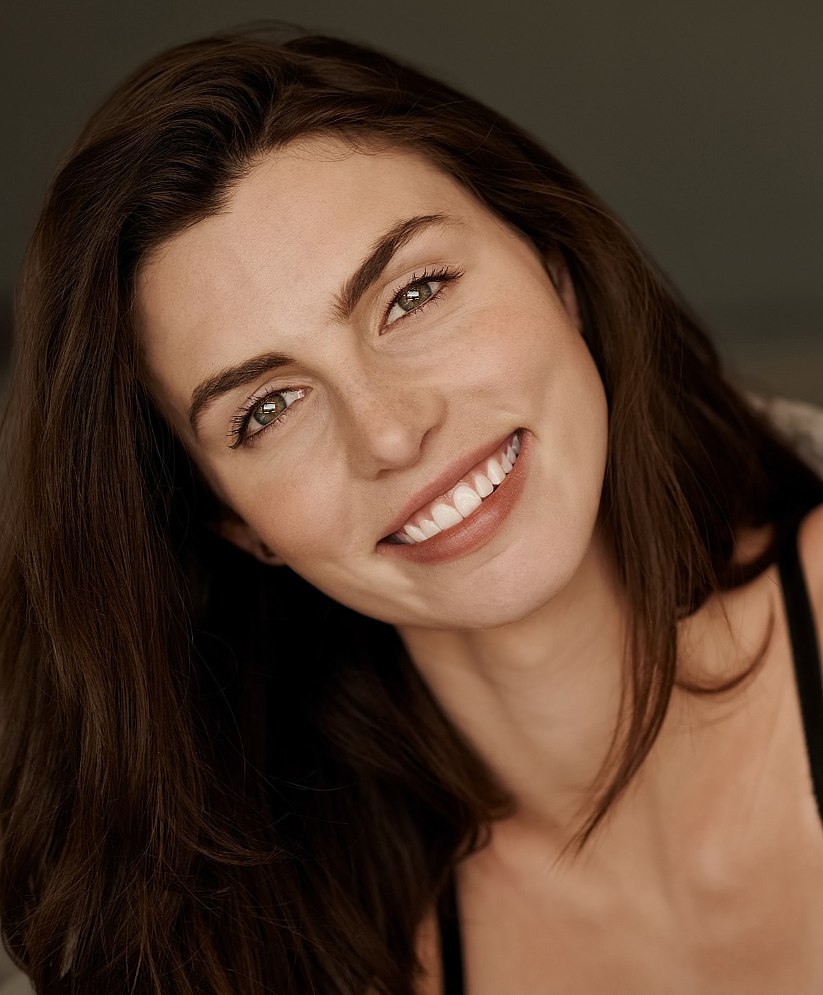 Smiling woman with long, dark hair.
