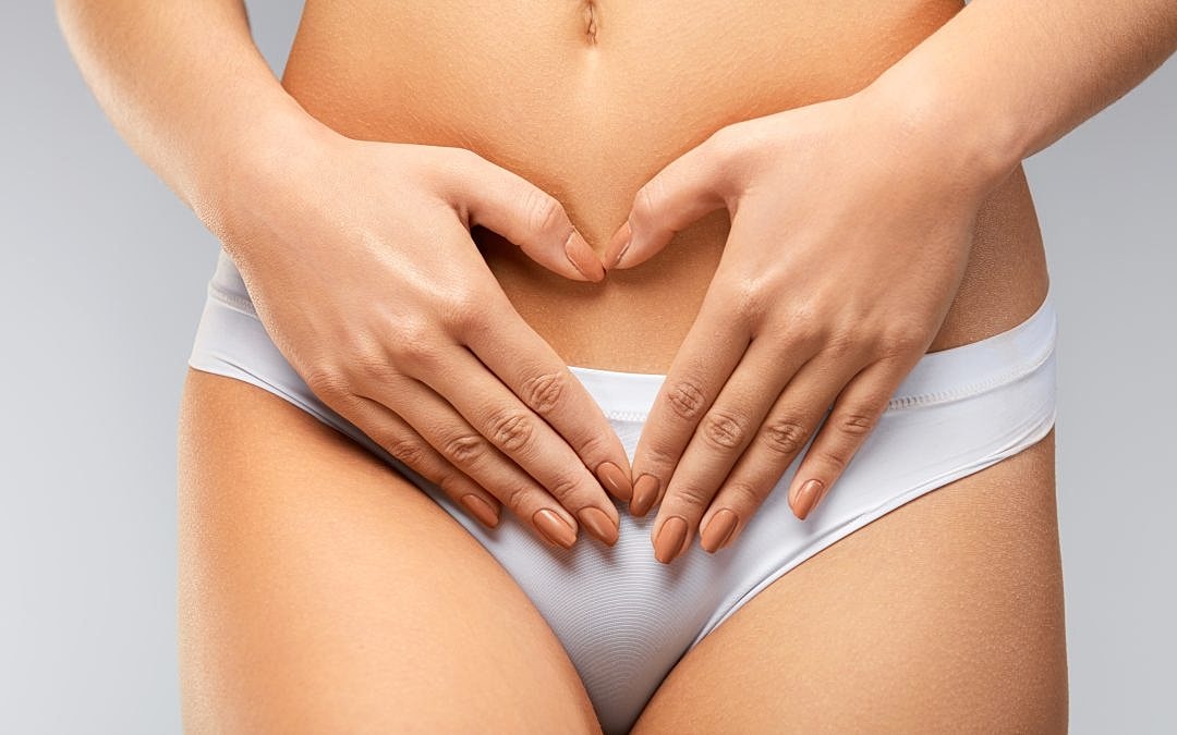 Woman forming heart shape on stomach.