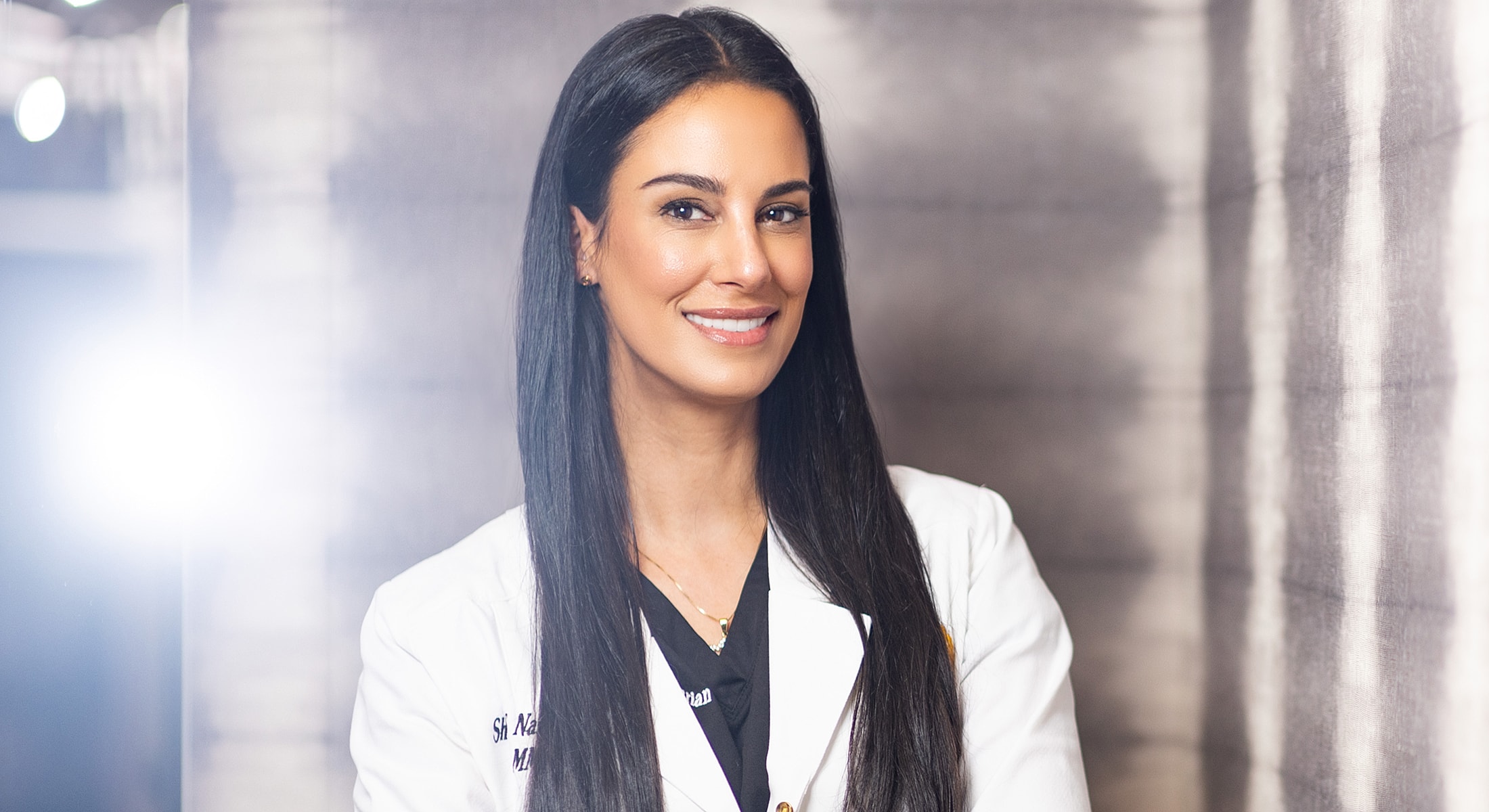 Smiling healthcare professional in white lab coat.