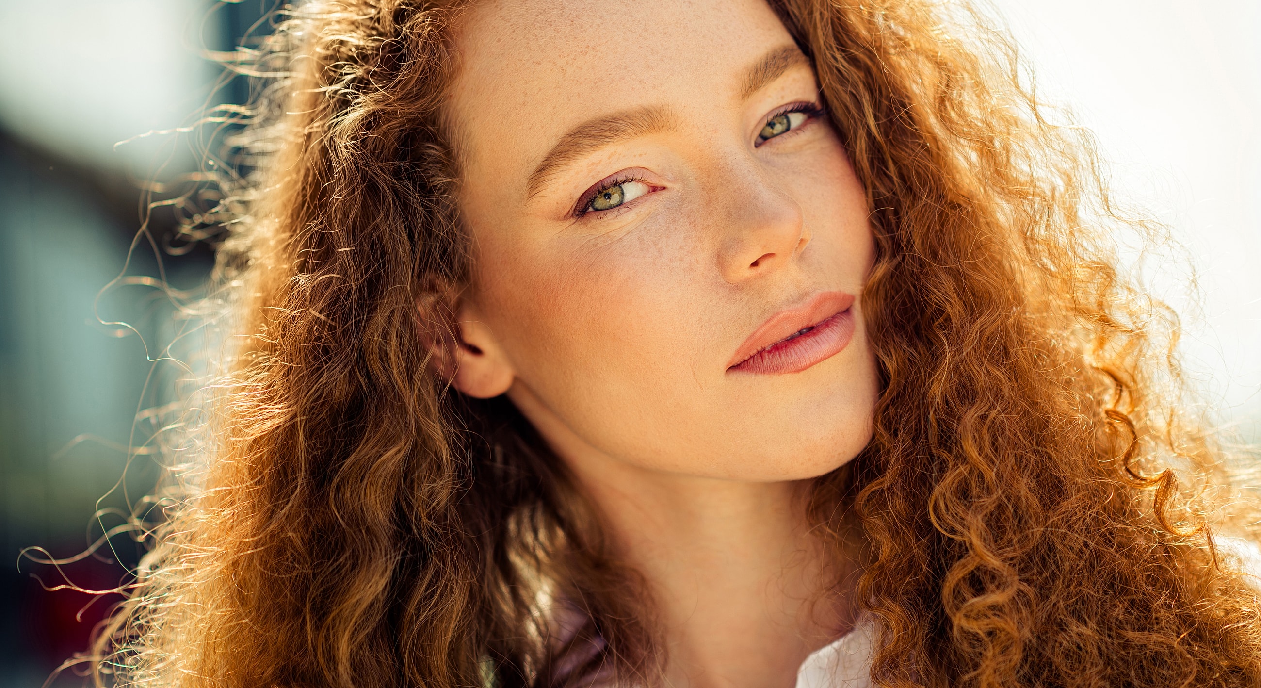 Young woman with curly hair, natural sunlight.