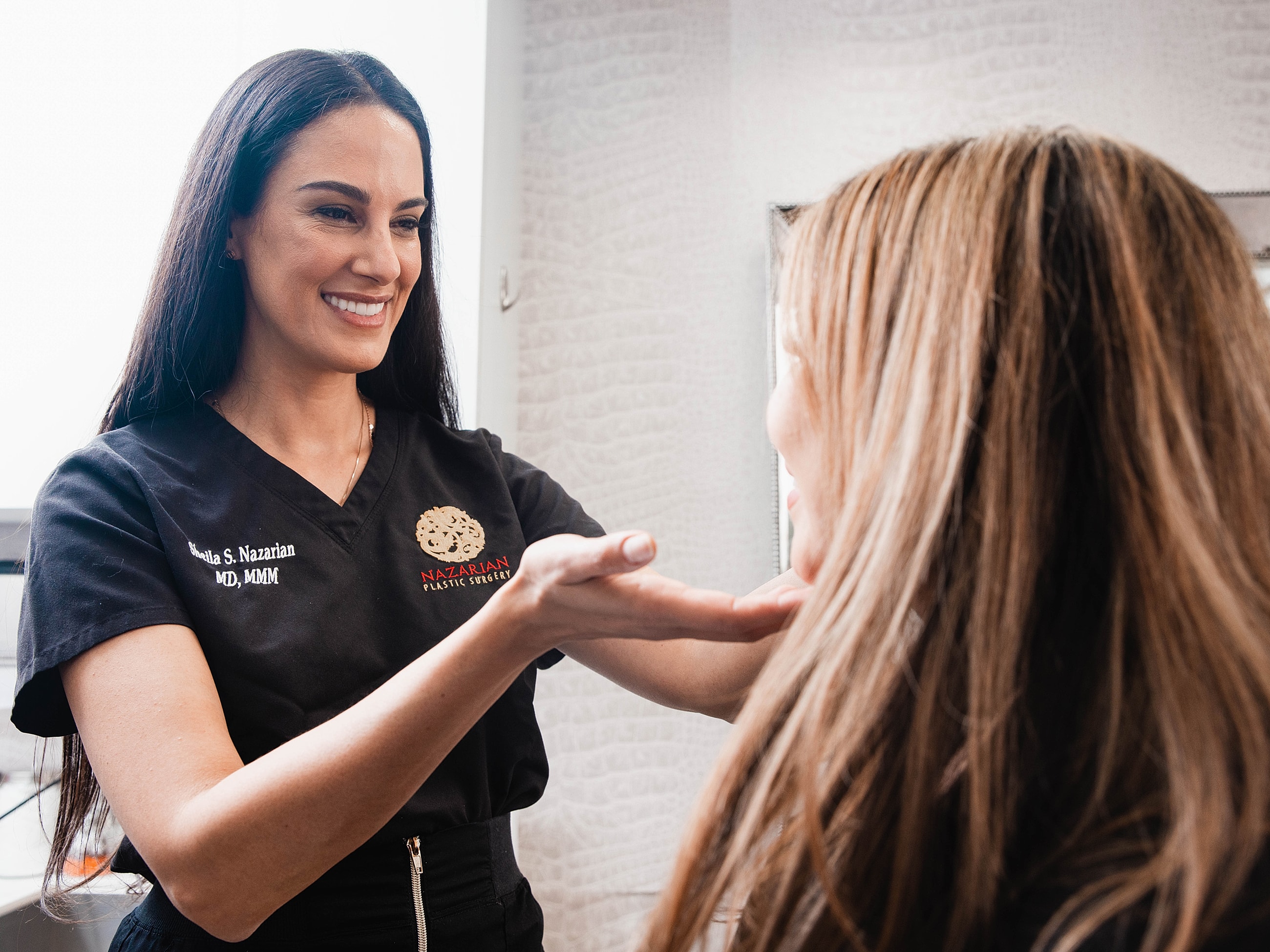 Smiling woman resting chin on hands.