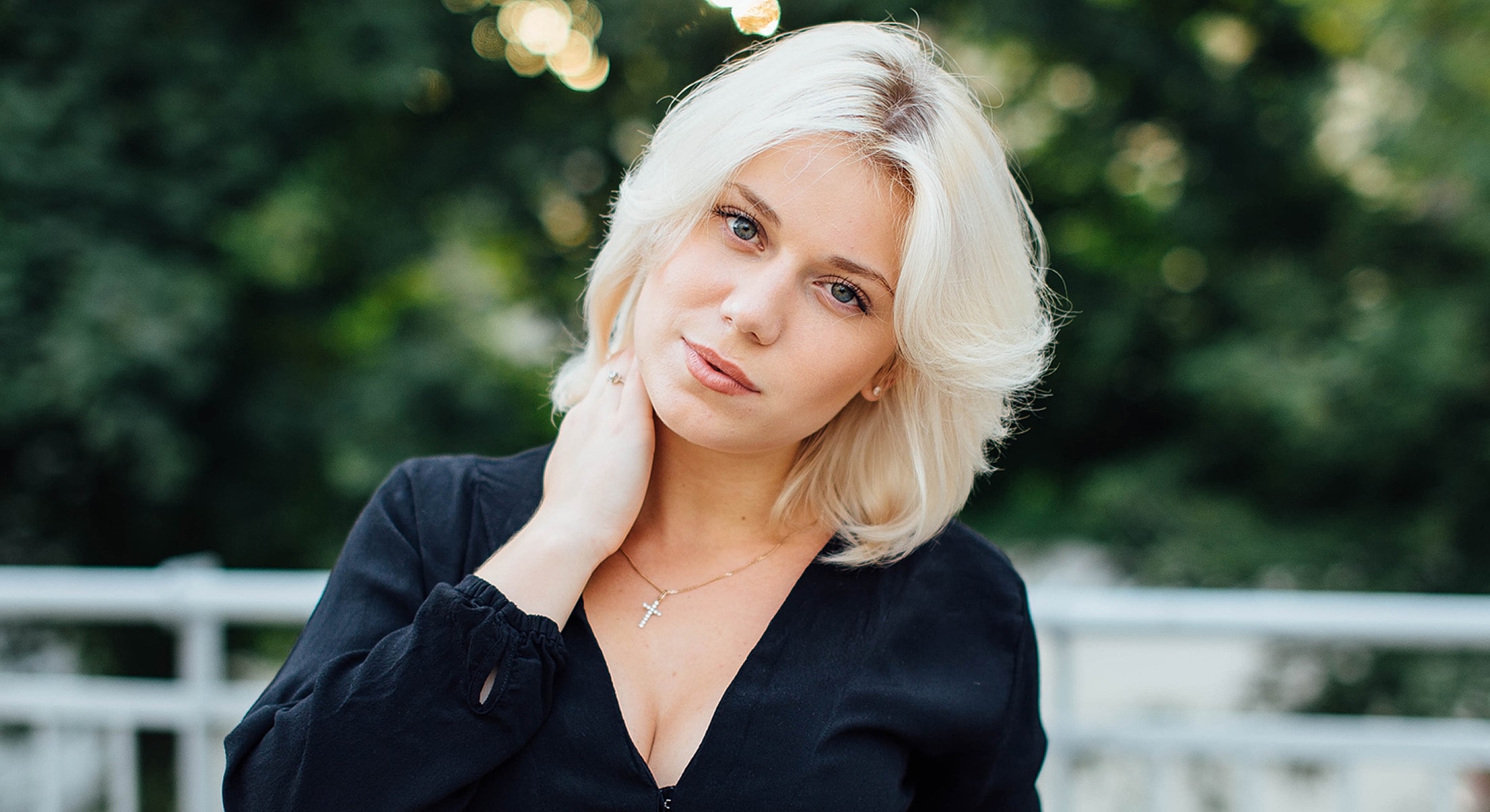Woman with blonde hair posing outdoors.
