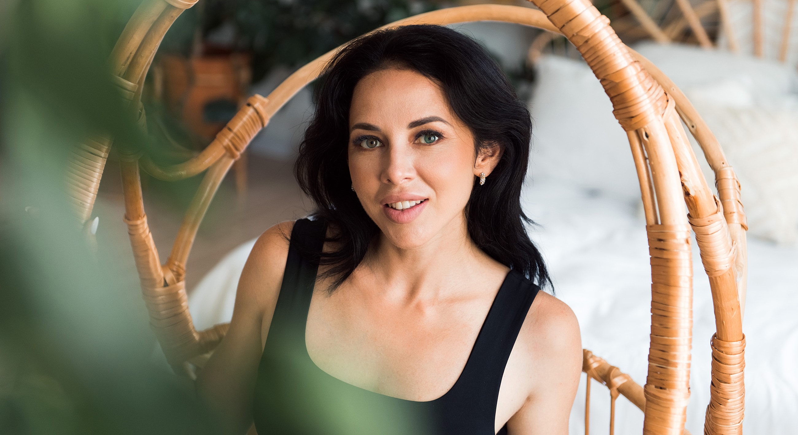 Woman relaxing in a wicker chair indoors.